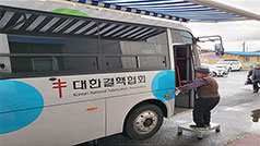 대한결핵협회라고 써진 버스에 올라타고 있는 남자 노인의 뒷모습