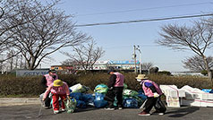 야외에 쌓여있는 쓰레기봉투 앞에서 쓰레기를 줍거나 정리하고 있는 노인들 모습