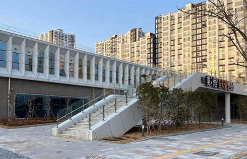 빛가람꿈자람센터건물전경.계단이있는현대적인2층구조의건물뒤로아파트단지가보이는모습.