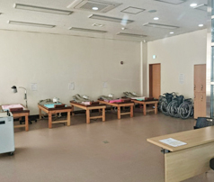 물리치료 침대와 휠체어가 보이는 물리치료실 전경