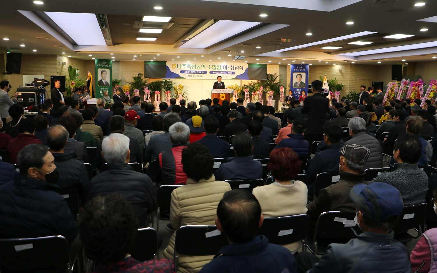 나주축협 조합장 이, 취임식 참석자들 모습이 보이고 나주시장의 축사 모습 행사장 전면