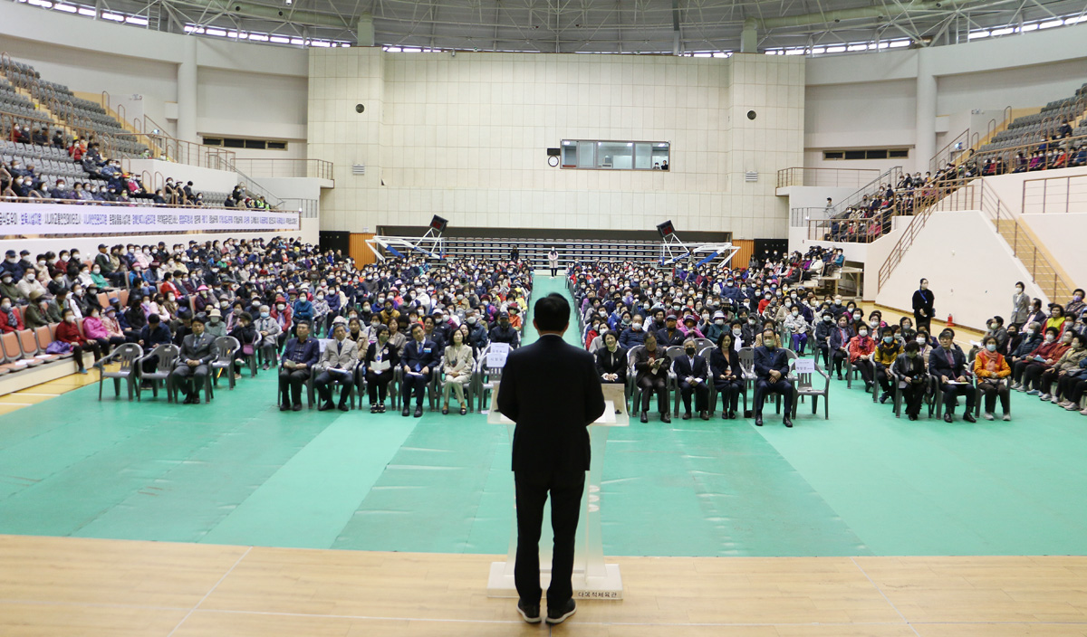 노인일자리 사업 발대식 무대 뒤쪽에서 참석자들의 얼굴이 보이고 나주사장의 축사 뒷모습이 보이는 전면