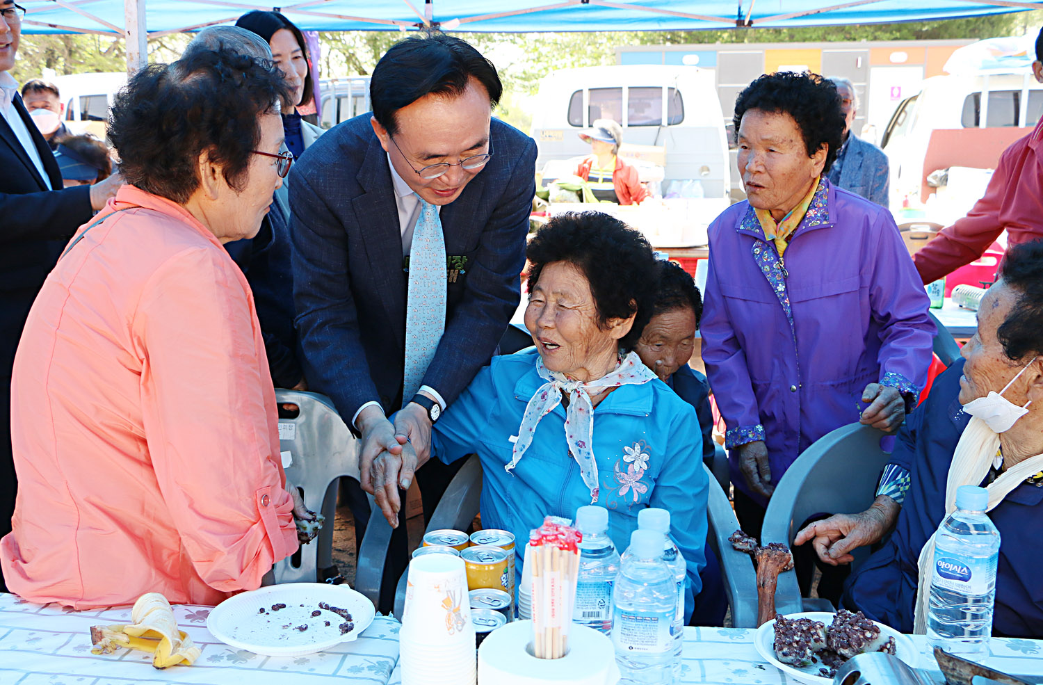제39회 봉황면민의 날 행사 나주시장이 행사장 부스에 계시는 여자어르신의 손을 잡아주며 인사를 나누는 모습