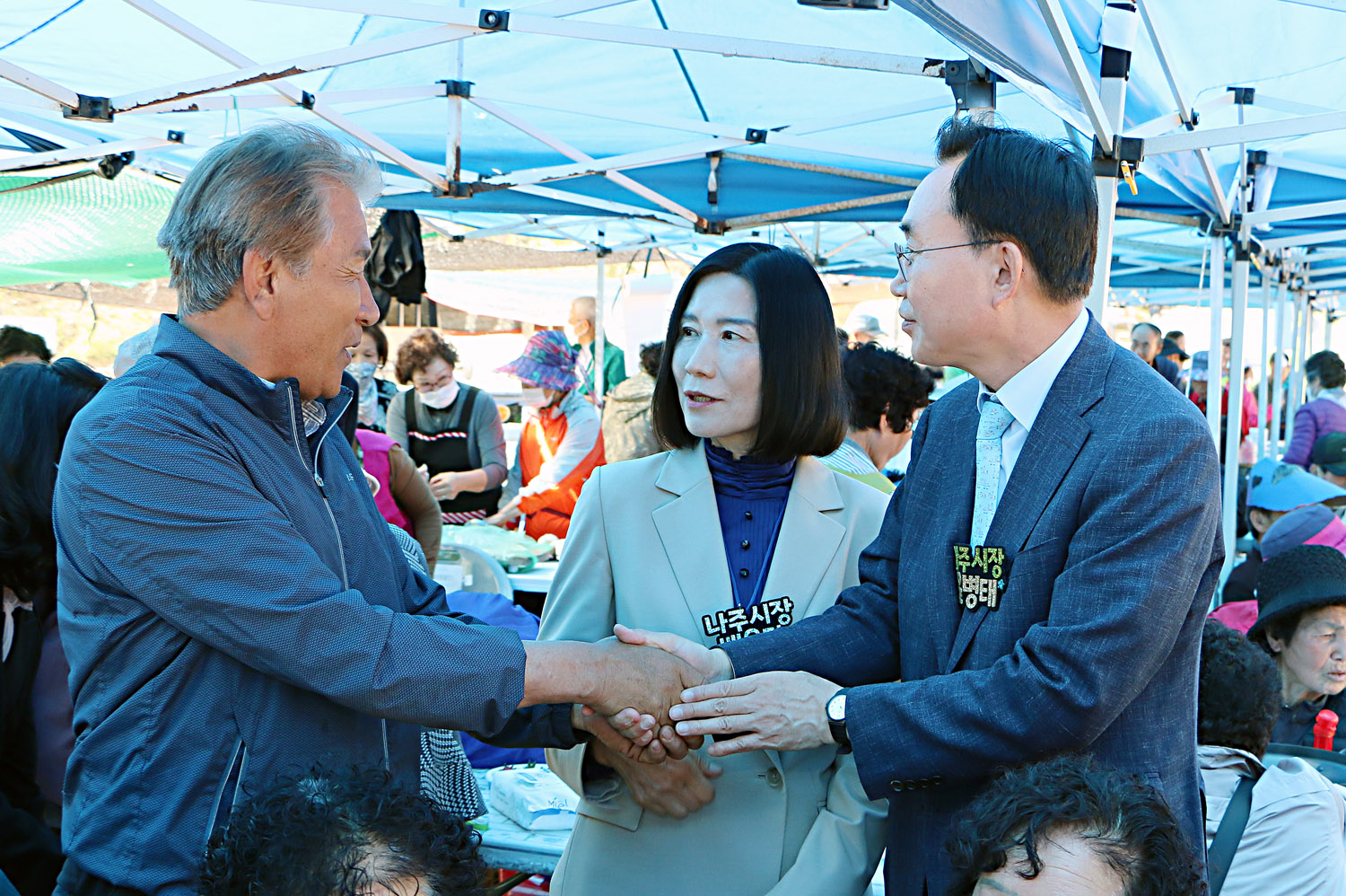 제39회 봉황면민의 날 행사 나주시장이 부스에서 남자 주민분과 악수를 나누며 이야기를 하고 있는 모습