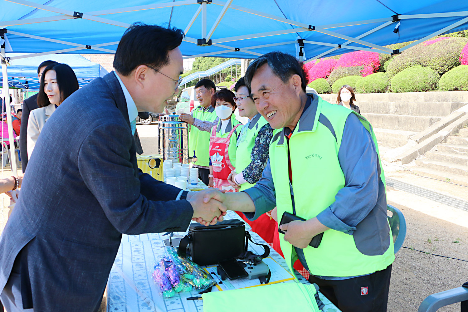 제39회 봉황면민의 날 행사 나주시장이 봉황면 주민자치위원회에서 준비한 부스에서 남자 주민분과 악수를 나누는 모습