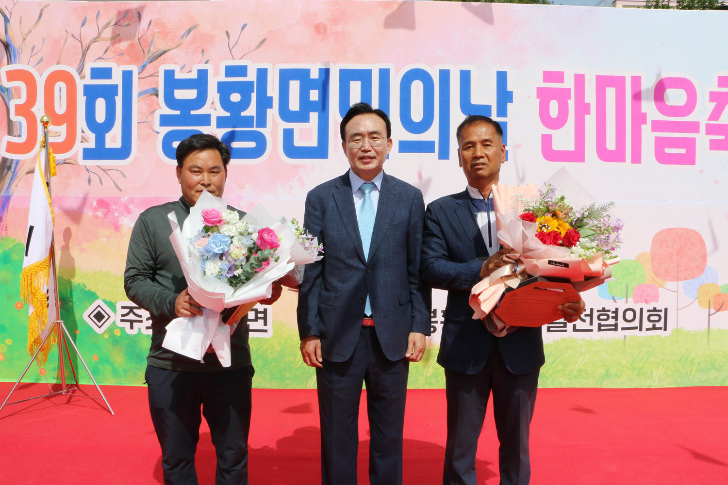 제39회 봉황면민의 날 행사 나주시장이 무대 위에서 시상자들과 기념촬영을 하고 있는 모습