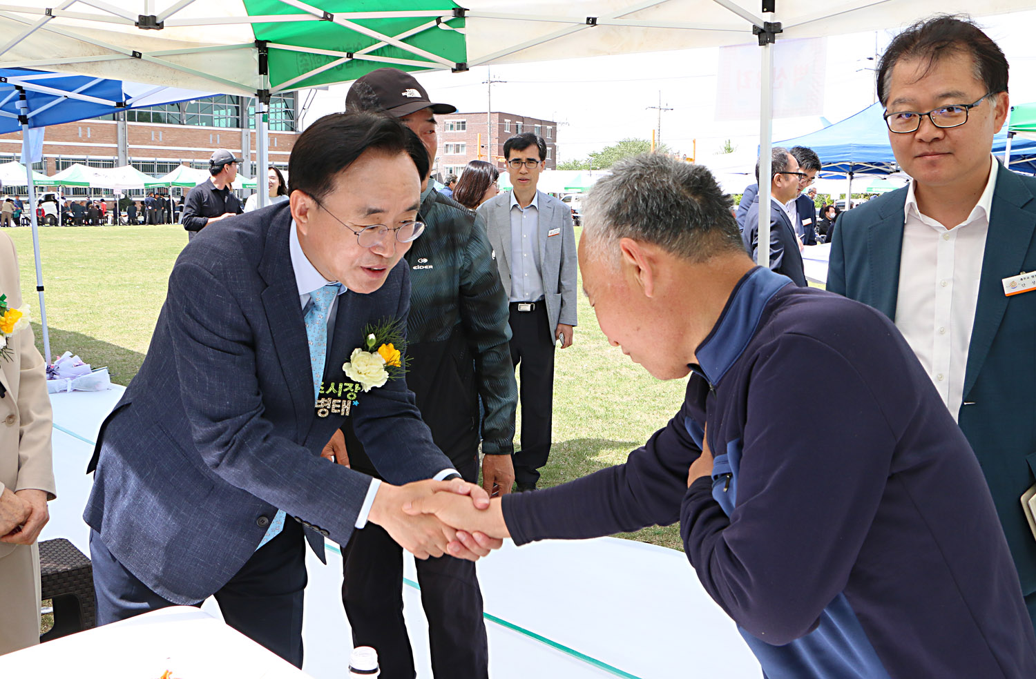 제25회 세지면민의 날 행사 행사장 부스에서 남자 주민분과 악수를 나누고 있는 나주시장 모습