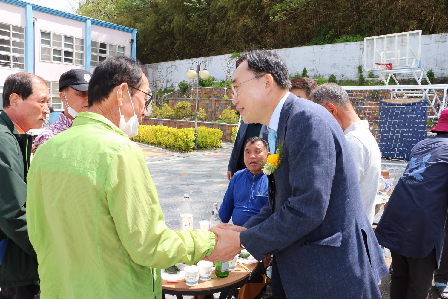 제25회 세지면민의 날 행사 행사장 한편에서 음식을 드시고 있는 주민분과 악수를 나누고 있는 나주시장 모습