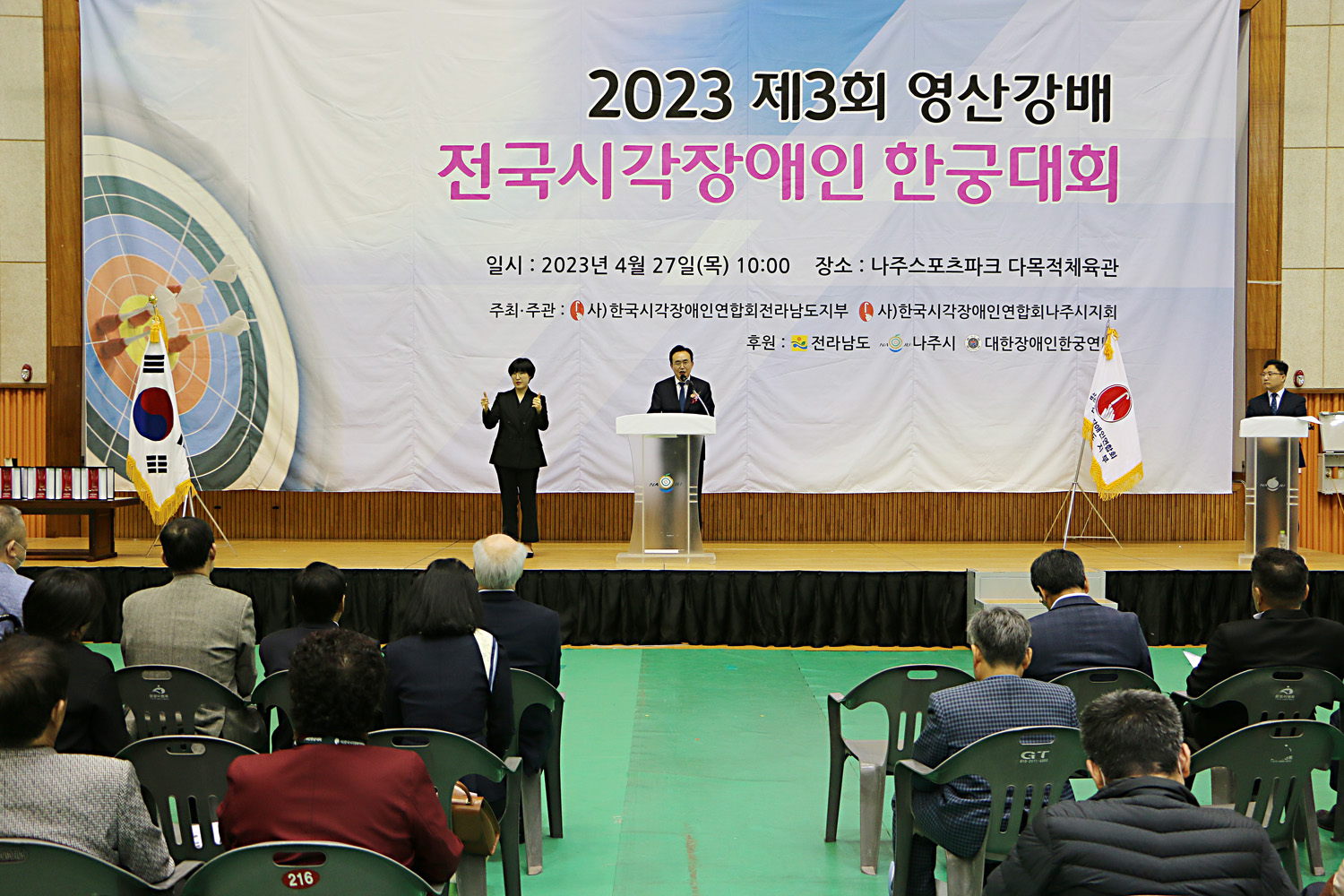 영산강배 전국 시각장애인 한궁대회 개회식 참석자들의 뒷모습이 보이고 나주시장이 환영사를 하고 있는 모습