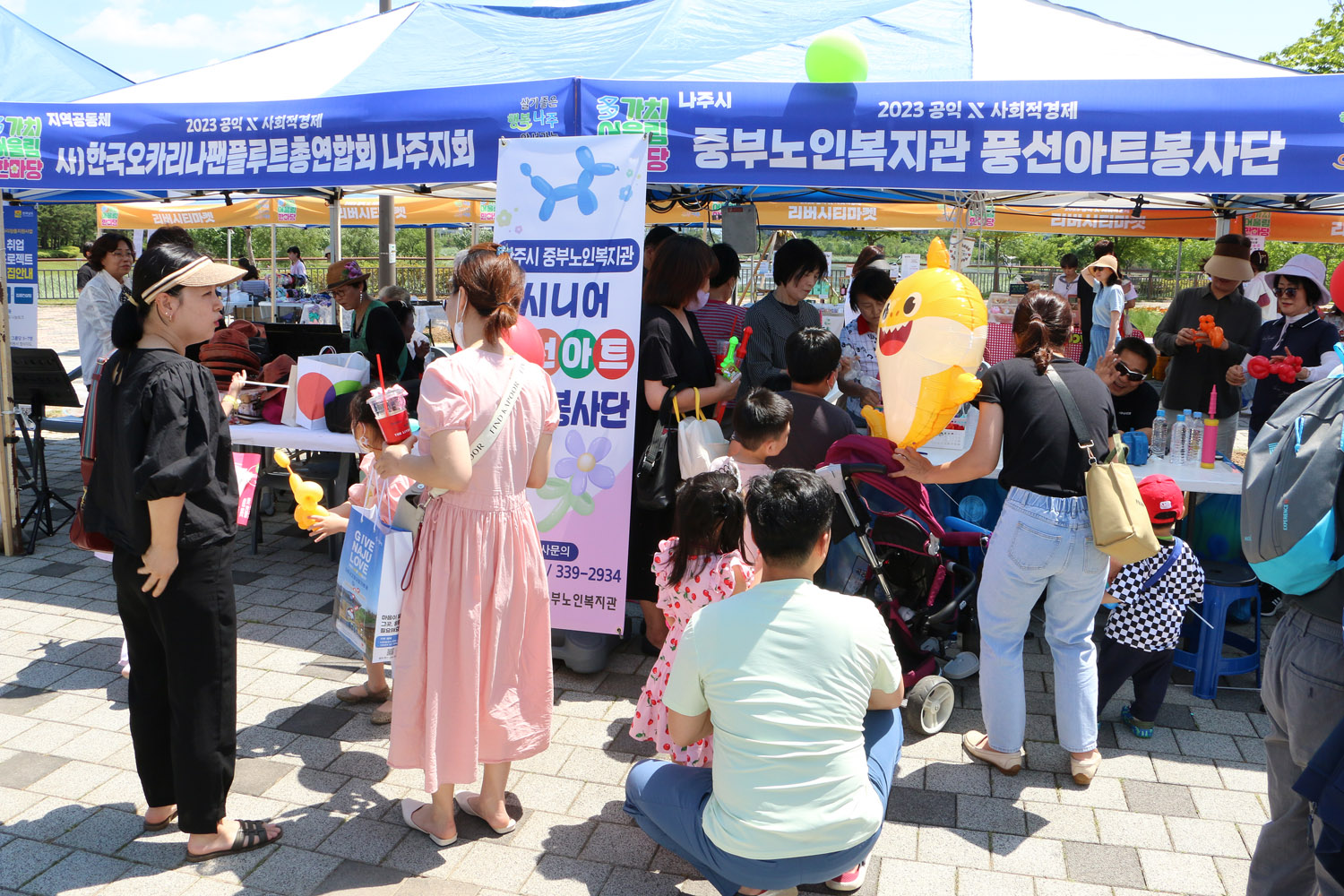多가치 어울림 한마당 기념식 행사장 부스 앞에서 풍선을 받기 위에 대기 하고 있는 가족들의 모습