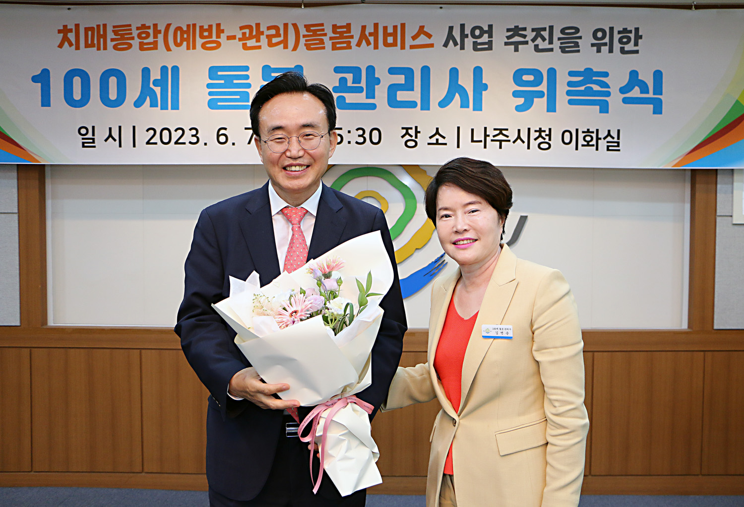 100세 돌봄 관리사 위촉식 돌봄관리사 대표자 분이 나주시장에게 꽃다발 전달 후 함께 기념촬영 모습