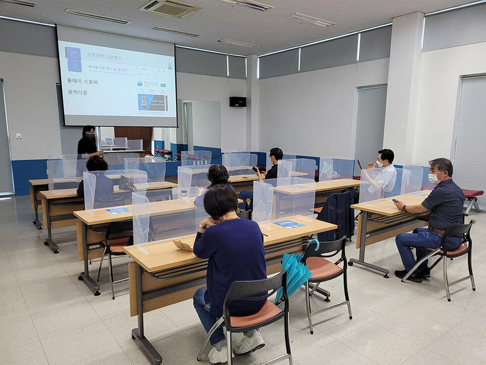 디지털역량강화 교육장에서 스마트폰을 보면서 설명을 듣고 있는 교육생들 모습