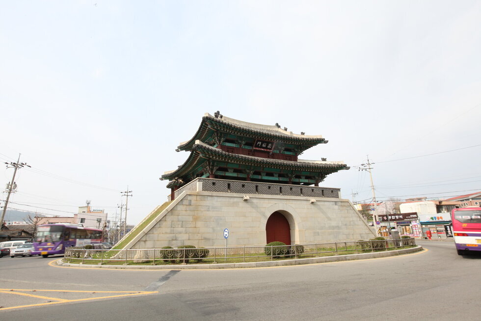 남고문 측면을 찍은 사진. 로터리 형식으로 남고문이 있고 그 주위로 차량이 운행되고 있으며 가지런하게 깍은 대리석의 성벽과 나무로된 성문이 보이고 2층 기와에 남고문이라고 한문으로된 현판이 걸려 있음.