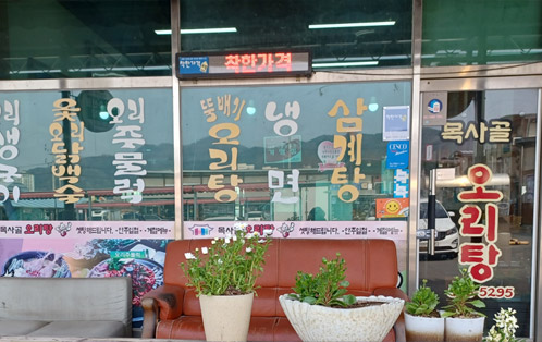 목사골 오리탕으로 창문에 삼계탕, 냉면, 뚝배기오리탕, 오리주물럭, 옻오리닭백숙등 메뉴판이 적혀있다.