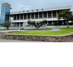 나주배박물관 전경으로 사각의 지붕아래 둥근기둥들이 무수히 둘러싸고 있으며 입구에 나주배를 들고있는 캐릭터 동상이 있다.