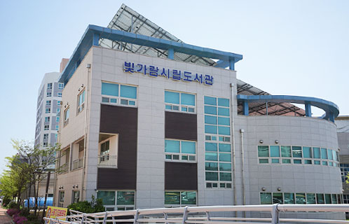 회색건물로 옆쪽에는 둥근 아치형의 건물과 직사각형의 건물로 이어진 빛가람시립도서관 전경