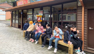 다방 밖 평상위에 어린이들이 앉아 있는 모습