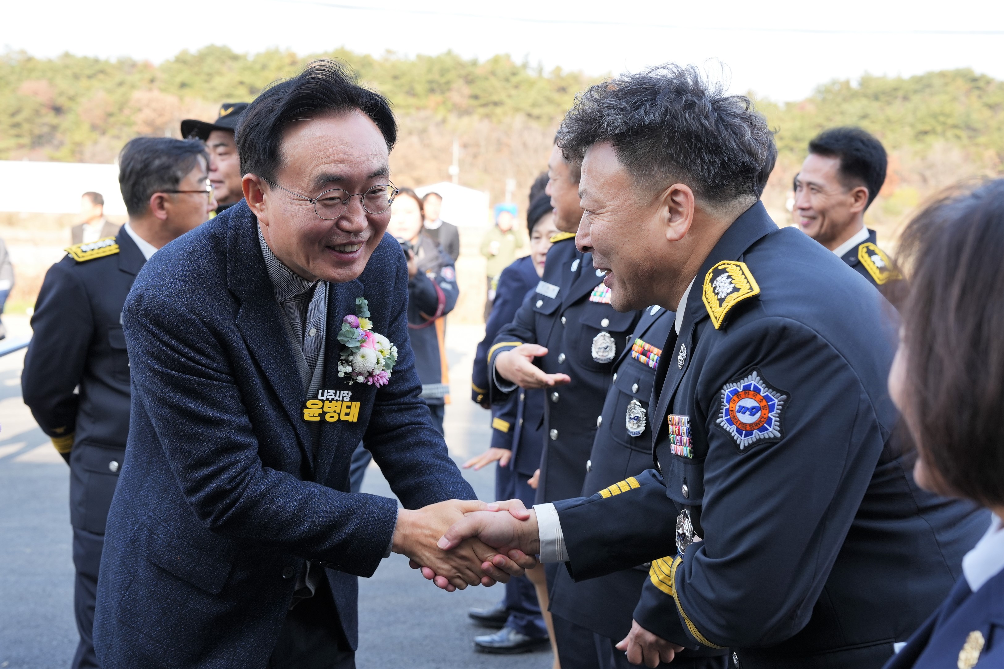 세지 119 지역대 개청식에서 윤병태 나주시장과 소방 관계자가 악수하며 웃는 모습