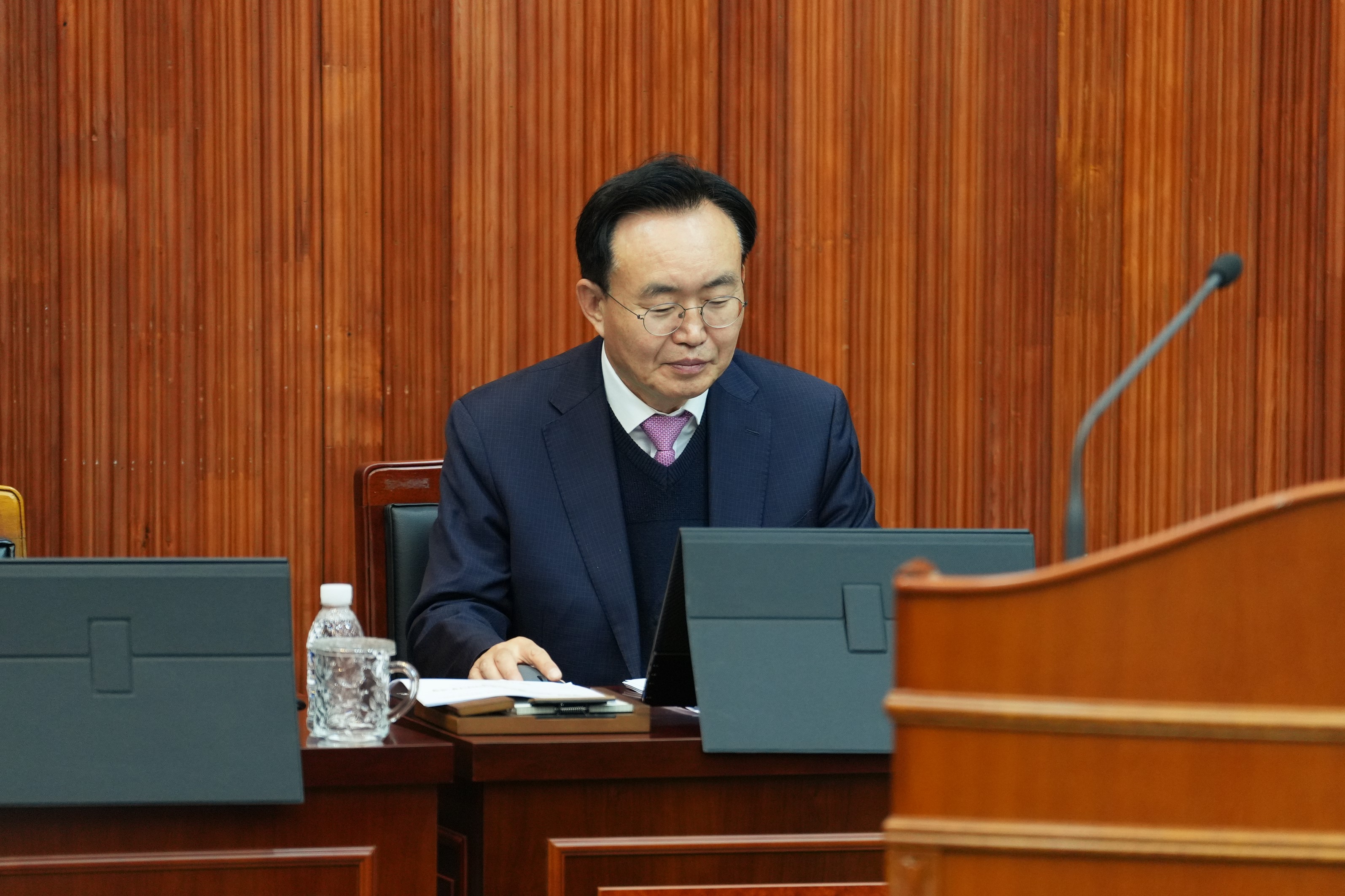  윤병태 나주시장이 회의장에서 앉아 태블릿 화면을 내려다보는 클로즈업 사진