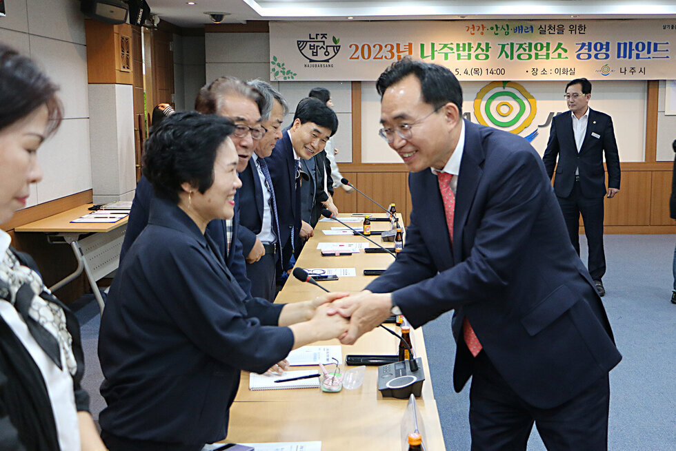 나주밥상 지정업소 경영 마인드 교육 나주시장이 업소 대표와 악수를 나누고 있는 모습
