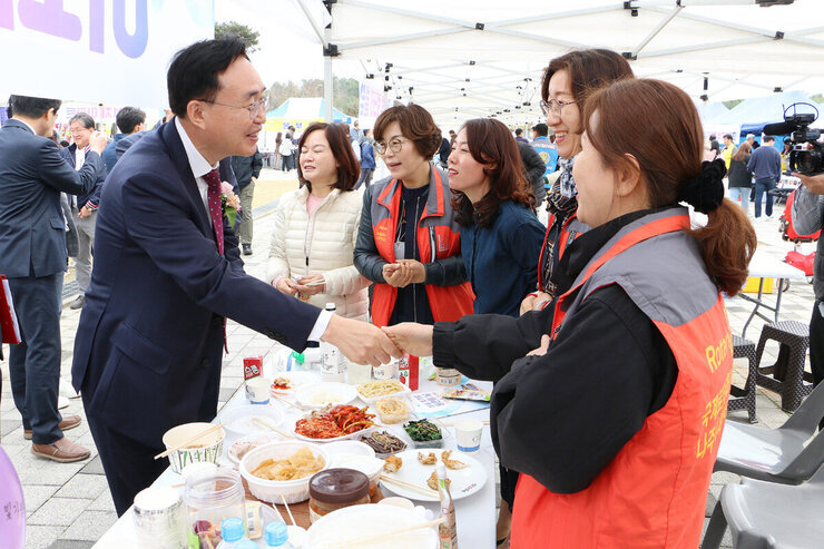 제1회 빛가람동민의 날 행사 국제로타리클럽 부스에서 회원들과 악수하는 나주시장 모습