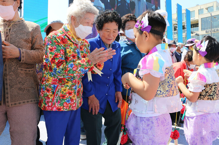 제19회 남평읍민의 날 행사 여성 어르신이 남자 아이에게 고마움의 표시로 박수를 쳐주고 있는 모습