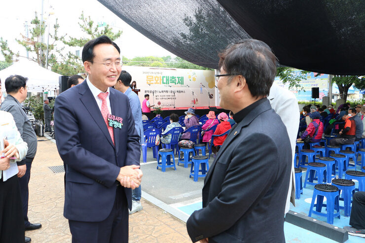 나주시노인복지관 문화대축제 행사 나주시장과 축제 관계자가 서 있는 자세로 행사장에서 이애기를 나누고 있는 모습
