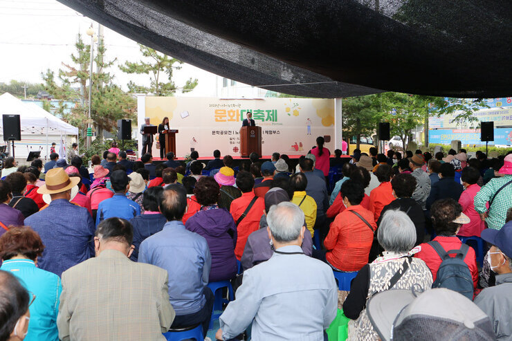 나주시노인복지관 문화대축제 행사 나주시장의 축사 모습 행사장 무대 앞의 앉아 있는 어르신들의 뒷모습이 함께 보인다