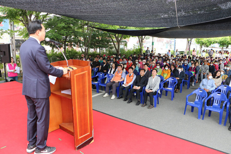 나주시노인복지관 문화대축제 행사 무대 위 뒷편에서 나주시장의 축사하는 옆모습이 보이고 참석자들의 앉아있는 앞모습이 보이는 전면 사진