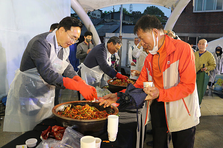 제19회 영산포 홍어축제 개막행사 나주시장이 무대 위로 올라온 시민 남성에게 홍어무침을 나누어 주고 있는 모습