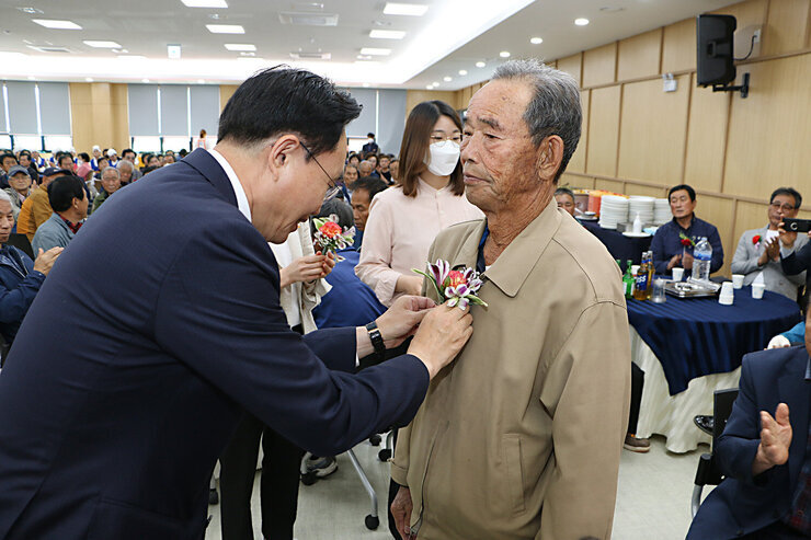 제51회 봉황면 어버이날 기념행사 나주시장이 또 다른 남자 어르신께 카네이션을 달아 드리는 모습