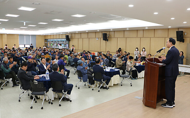 제51회 봉황면 어버이날 기념행사 행사장  단상 뒷쪽에서 참석자들의 앉아있는 모습이 보이고 나주시장의 축사하는 뒷모습