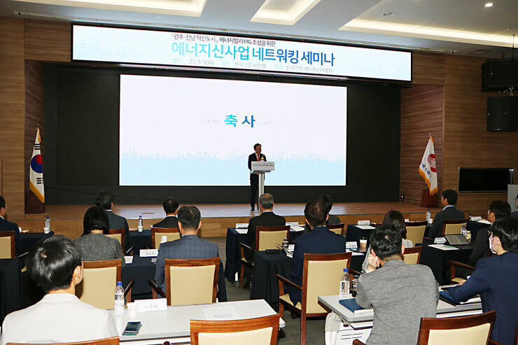 에너지밸리 MG 조성 네트워킹 세미나 나주시장이 축사를 하고 있고 참석자들의 앉아 있는 모습이 보이는 세미나장 모습