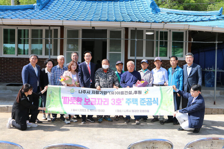 따뜻한 보금자리 3호 주택 준공식 나주시장과 시의회 의장, 주택 공사 담당 대표, 주택 주인 등 관계자들이 기념촬영을 하고 있는 모습