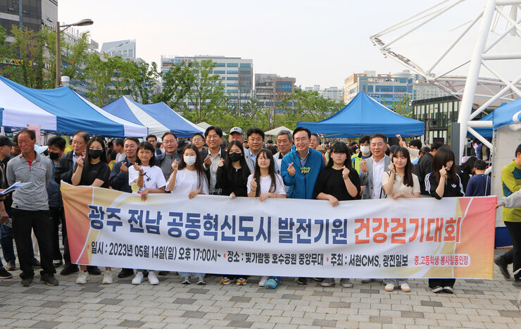 광주, 전남 공동혁신도시 발전기원 건강걷기대회 나주시장과 중학생 여자아이들, 도의원 등 관계자들과 현수막을 들고 손하트를 하며 기념촬영을 하고 있는 모습
