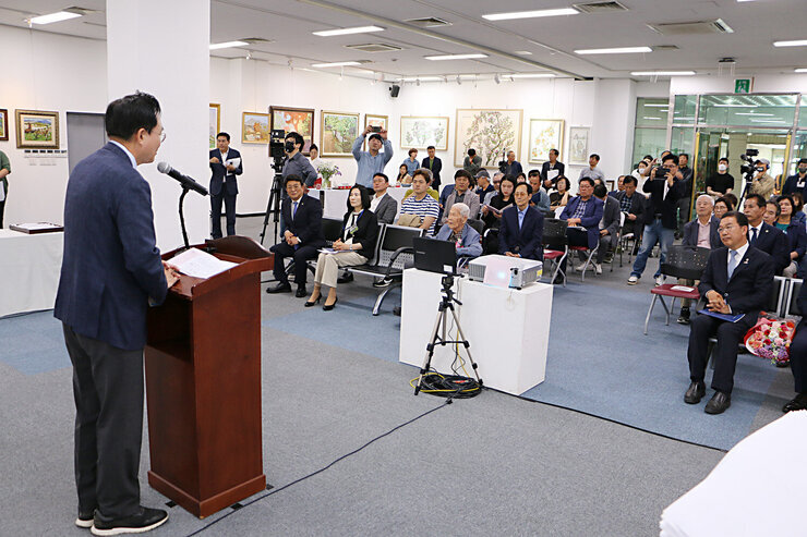 청운 김학동 화백 특별 회고전 나주시장이 축사를 하고 있는모습 참석자들의 앉아있는 앞모습과 나주시장의 뒷모습