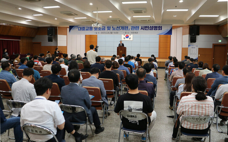 대중교통 보조금 및 노선개편 시민설명회 참석자들의 앉아 있는 뒷모습이 보이고 나주시장의 인사말 모습 전면