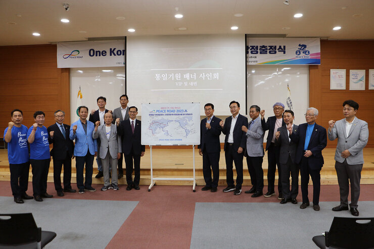 One Korea 피스로드 2023 전남 나주시 통일대장정 출정식  나주시장과 관계자들이 사인한 보드판을 중앙에 두고 기념촬영을 하고 있는 모습