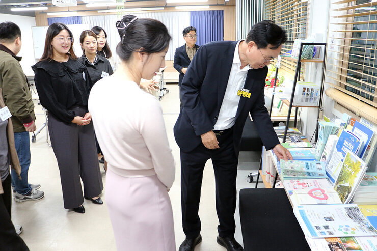 나주 청년과의 소통 간담회 나주시장이 청년센터 내부를 둘러보며 탁자 위의 팜프렛을 손으로 가리키고 있는 모습