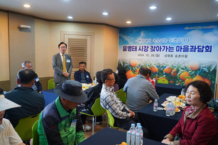 찾아가는 마을좌담회 나주시장이 자리에 서서 인사말을 하고 있고 참석 주민들이 자리에 앉아 듣고 있는 모습