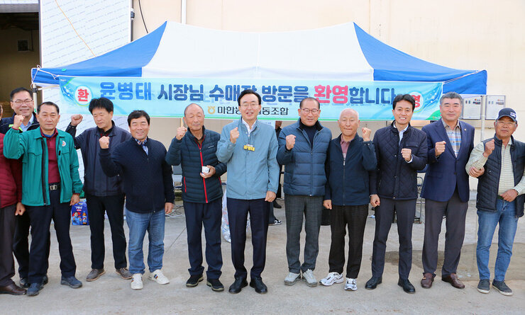 세지면, 왕곡면 수매현장 방문 나주시장과 세지면 농민이 함께 화이팅을 회치며 기념촬영을 하고 있는 모습
