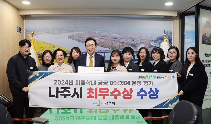 아동학대 공공대응체계 평가 최우수상 수상 나주시장과 아동복지과 간부 공무원 및 직원 10여명이 플래카드를 펼치고 기념촬영을 하고 있는 모습