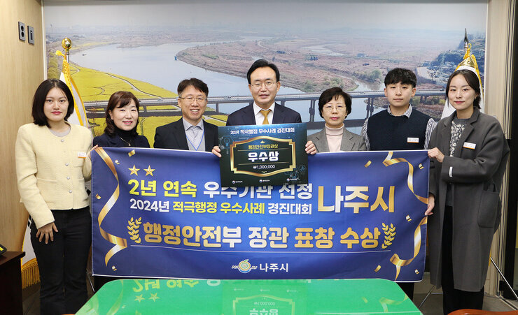 적극행정 우수사례 경진대회 행안부 장관 표창 수상 나주시장과 담당부석 직원들이 플래카드를 펼치고 기념촬영을 하고 있는 모습