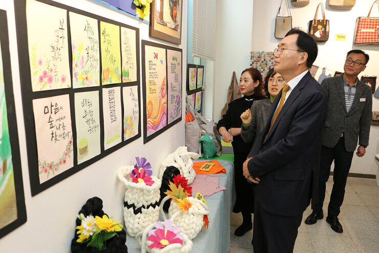LH5단지 프로그램 성과나눔 전시회 나주시장이 벽에 걸린 작품들을 바라보고 있는 모습