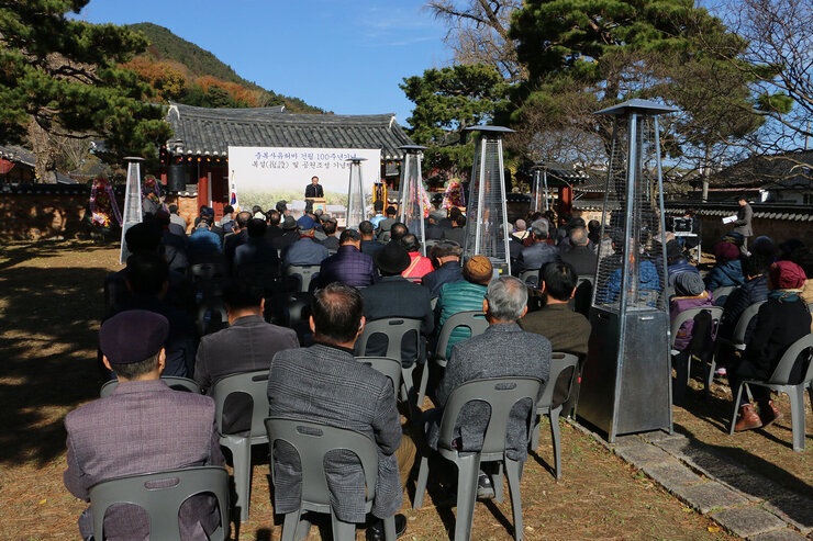 주향교 충복사유허비 건립 100주년 기념식 나주시장의 축사모습과 참석자들이 자리에 앉아 있는 뒷모습 전면
