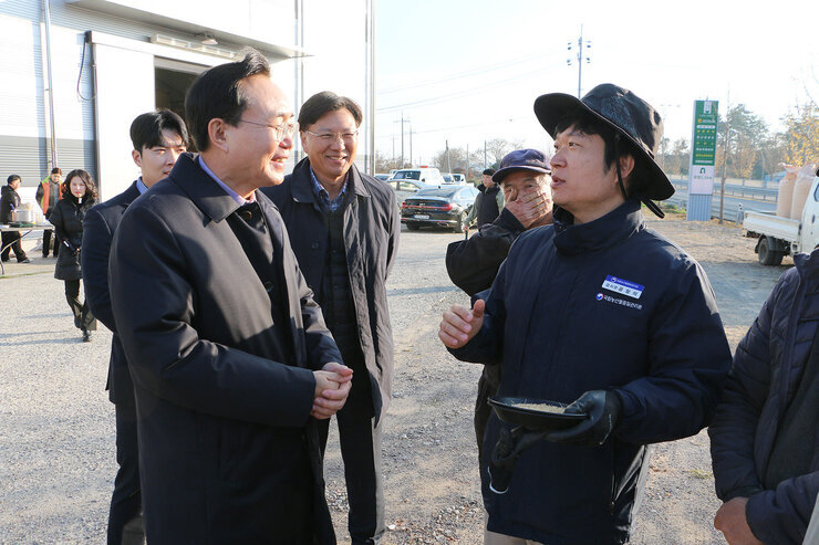 영산포 이창창고, 공산면 창고 수매현장 나주시장이 공산면 동촌창고를 방문하여 남성 품질관리원과 웃으며 대화를 나누는 모습