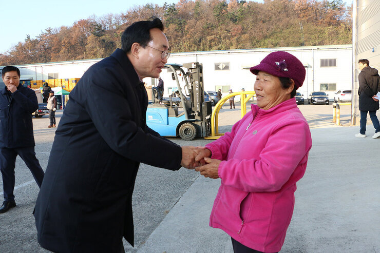 영산포 이창창고, 공산면 창고 수매현장 나주시장이 이창창고에서 여성 농민과 악수를 나누는 모습