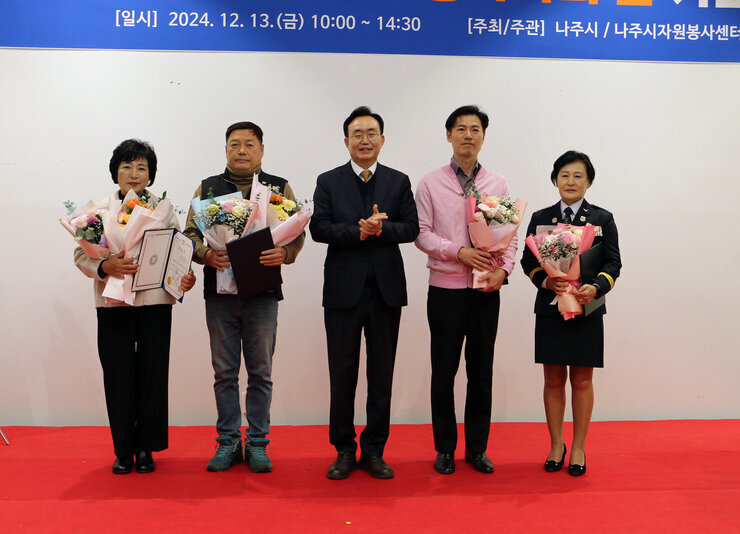 자원봉사자의 날 기념행사 나주시장과 시상을 받은 4명이 기념촬영을 하고 있는 모습