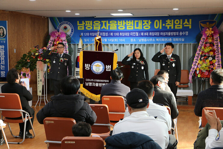 남평읍 자율방범대장 이취임식 방범대 남성, 여성 임원들이 취임식장 앞으로 나가 거수경례를 하고 있는 모습