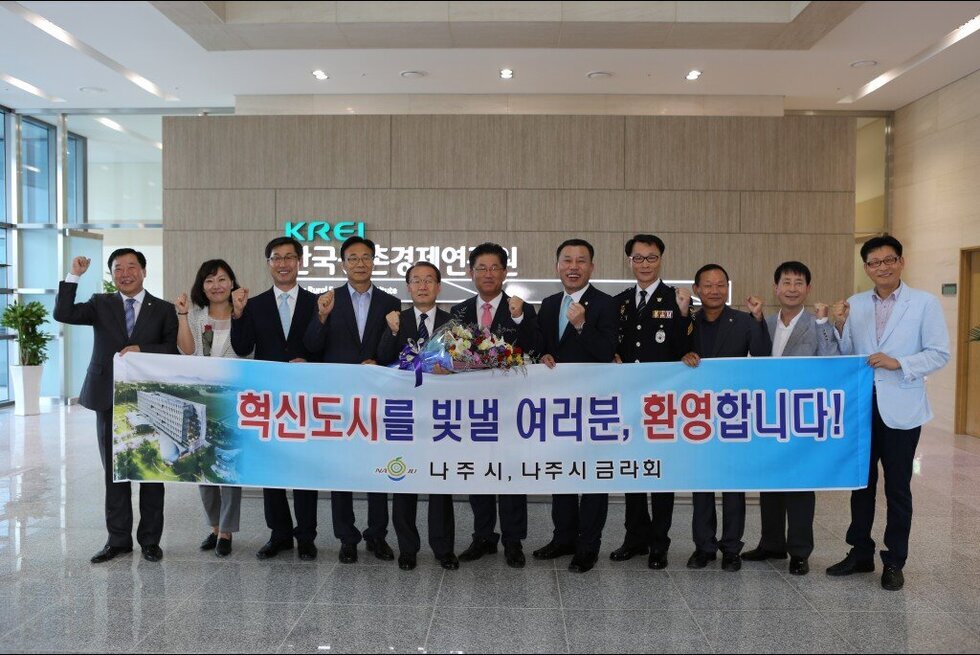 한국농촌경제 연구원에서 혁신도시를 빛낼 여러분 환영합니다 플랜카드와 함께 단체 사진촬영
